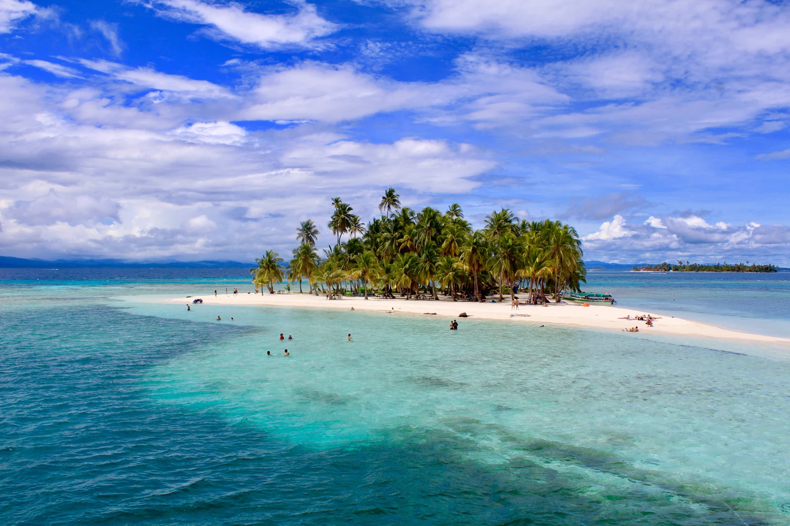 A palm-covered island surrounded by clear Caribbean water